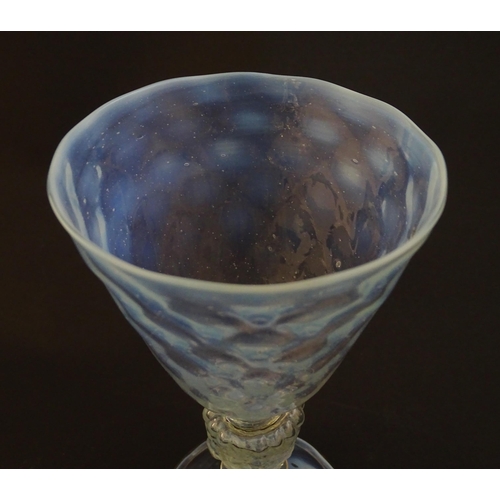 202 - A Venetian glass goblet / pedestal drinking glass with vaseline detail. Approx 6 3/4