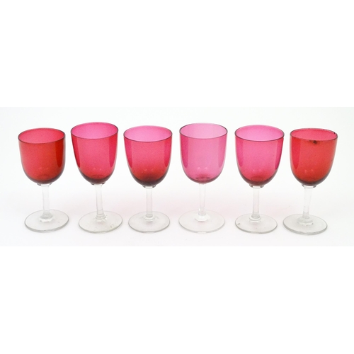 203 - Six assorted cranberry glass drinking glasses, with cranberry coloured bowls and clear glass stem an... 