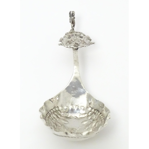 275 - A Dutch silver caddy spoon with embossed decoration. Approx. 4 3/4