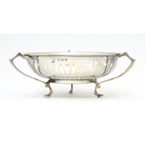 299 - A silver bon bon dish with pierced decoration and three handles raised on three feet. Hallmarked Bir... 