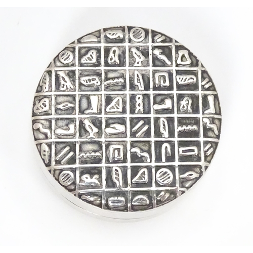 315 - An Egyptian white metal pill box with hieroglyphics decoration to lid.  Approx. 1 1/4