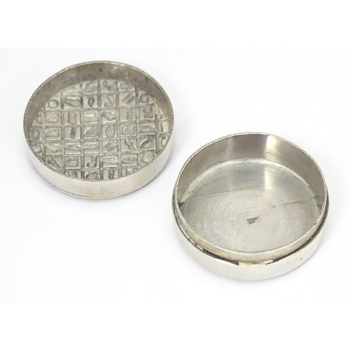 315 - An Egyptian white metal pill box with hieroglyphics decoration to lid.  Approx. 1 1/4