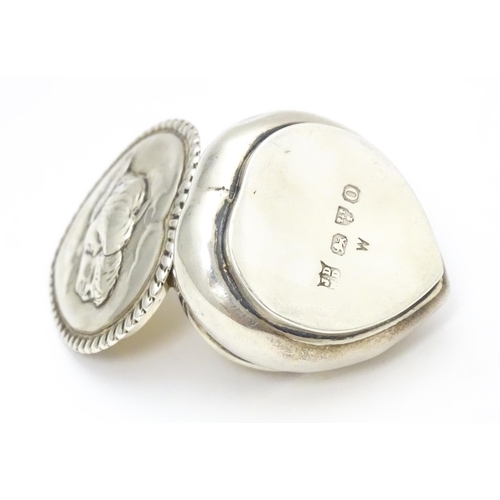 320 - A Victorian silver pill box of heart shape with hinged lid and embossed angel / cherub detail to top... 