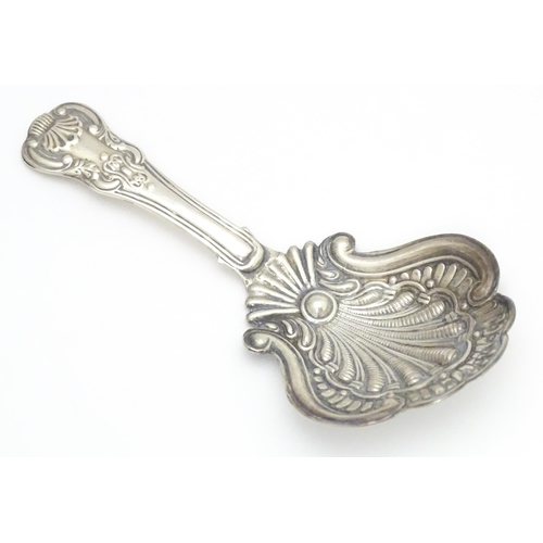 322 - A Victorian silver caddy spoon with shell formed bowl and scroll detail. Hallmarked Birmingham 1860 ... 