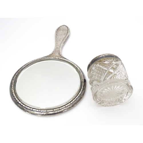 349 - A silver hand mirror and together with a silver topped glass dressing table pot. 2 1/2