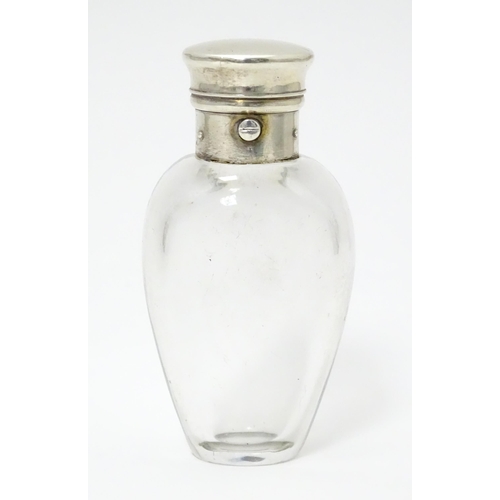 368 - A glass scent / perfume bottle with white metal lid opening to revival Crown mark titled WES. Approx... 