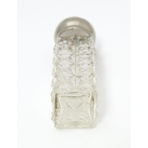 386 - A cut glass scent / perfume bottle with white metal collar having acanthus scroll decoration togethe... 