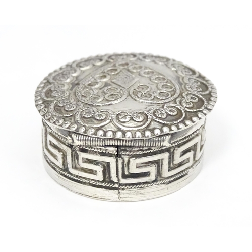 392 - A white metal pill box of circular form heart detail to lid. Approx. 1 1/4