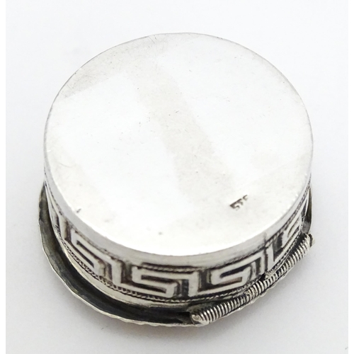 392 - A white metal pill box of circular form heart detail to lid. Approx. 1 1/4