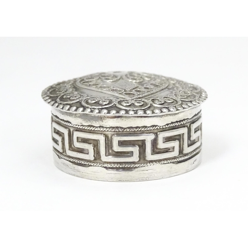 392 - A white metal pill box of circular form heart detail to lid. Approx. 1 1/4