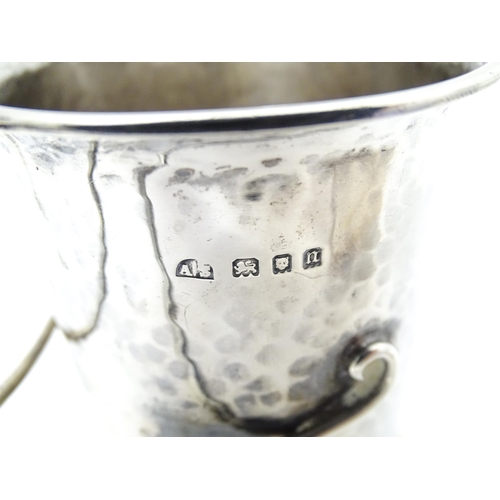 404 - An Arts & Crafts silver christening mug with hammered decoration, banded spherical ball detail and b... 