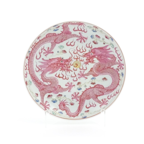 17 - A Chinese famille rose dragon dish with two dragons, flaming pearl and stylised clouds. The reverse ... 
