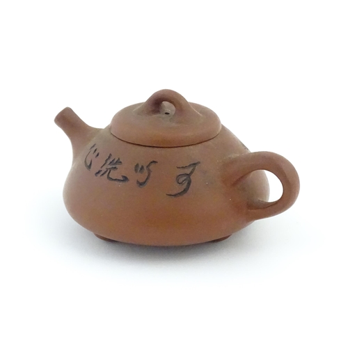 52 - A Chinese Yixing teapot with incised tree and script detail. Character marks under and to underside ... 