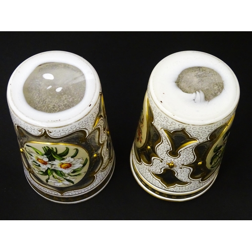 185 - Two 19thC Bohemian glass beakers with white overlay, gilt highlights and hand painted floral sprays.... 