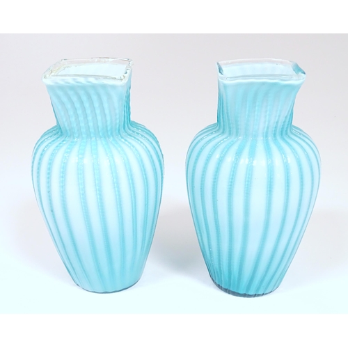 197 - Two turquoise trailed glass vases. Approx 9 1/4