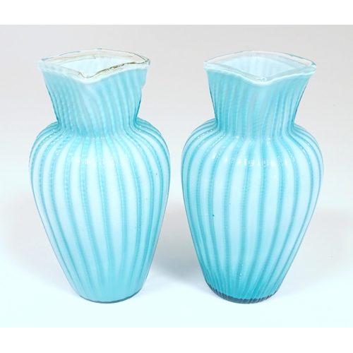 197 - Two turquoise trailed glass vases. Approx 9 1/4