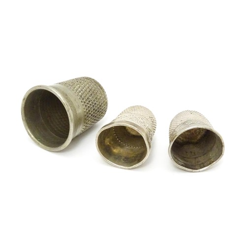 466 - Three thimbles comprising a silver thimble hallmarked Chester 1903, maker Charles Horner, and two si... 