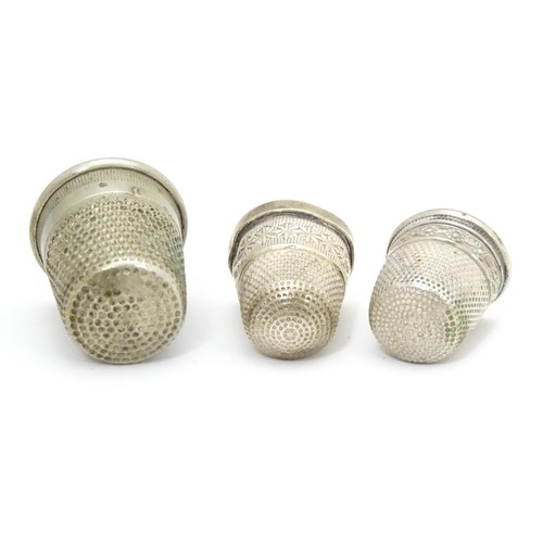 466 - Three thimbles comprising a silver thimble hallmarked Chester 1903, maker Charles Horner, and two si... 