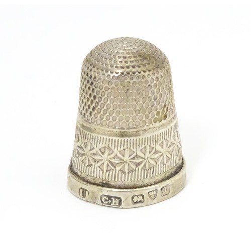 466 - Three thimbles comprising a silver thimble hallmarked Chester 1903, maker Charles Horner, and two si... 