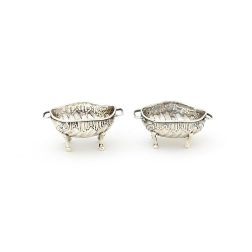 504 - A pair of Continental .930 silver salts with  engraved decoration and twin handles raised on four fe... 