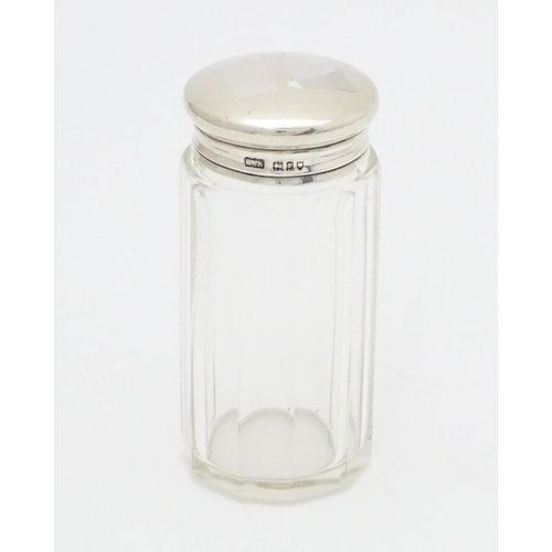 556 - A glass toilet / dressing table jar with silver lid hallmarked London 1912 maker Loebl & Co. 3 1/4