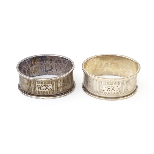 569 - A pair of napkin rings of oval form with engine turned decoration. Hallmarked Birmingham 1952 maker ... 