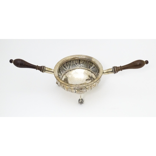 591 - A white metal brazier / ember bowl foliate detail and raised on three ball and claw feet with twin h... 