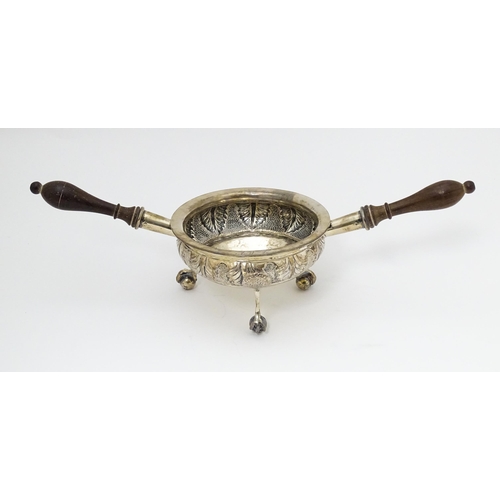 591 - A white metal brazier / ember bowl foliate detail and raised on three ball and claw feet with twin h... 