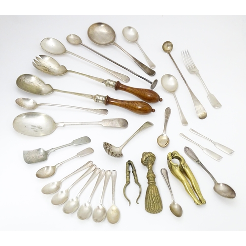 599 - A quantity of brass and silver plate ware to include various spoons, salad servers, nutcrackers to i... 