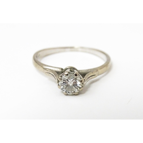 648 - A white metal ring set with central diamond solitaire. Diamond approx. 1/8