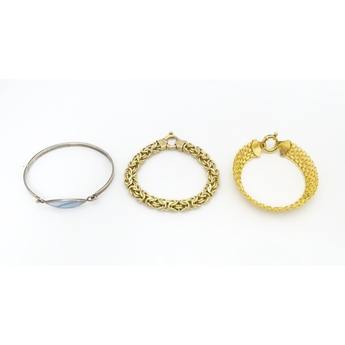 724 - Three assorted silver bracelets to include two silver gilt examples and a bangle formed bracelet (3)