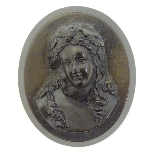 729 - A Victorian jet cameo brooch of oval form depicting a woman / bacchante with fruiting vines in her h... 