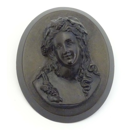 729 - A Victorian jet cameo brooch of oval form depicting a woman / bacchante with fruiting vines in her h... 