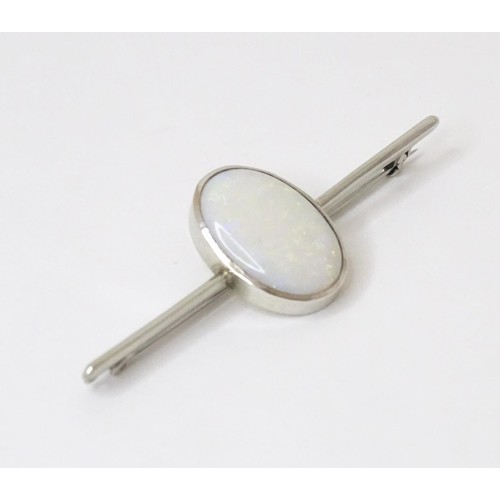 731 - A 9ct white gold bar brooch set with central oval opal cabochon. The opal approx. 3/4