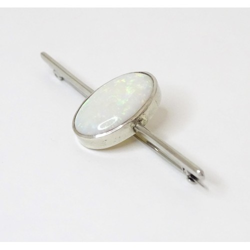 731 - A 9ct white gold bar brooch set with central oval opal cabochon. The opal approx. 3/4