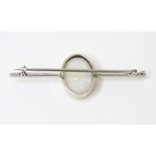 731 - A 9ct white gold bar brooch set with central oval opal cabochon. The opal approx. 3/4