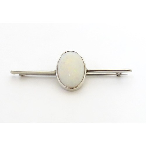 731 - A 9ct white gold bar brooch set with central oval opal cabochon. The opal approx. 3/4