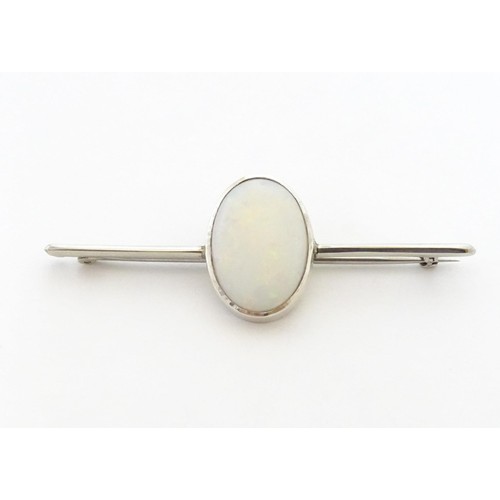 731 - A 9ct white gold bar brooch set with central oval opal cabochon. The opal approx. 3/4