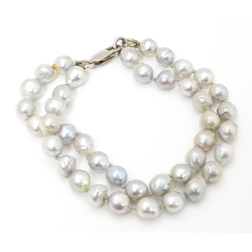 737 - Pearl jewellery comprising a two strand bracelet with silver clasp, a necklace with silver clasp and... 