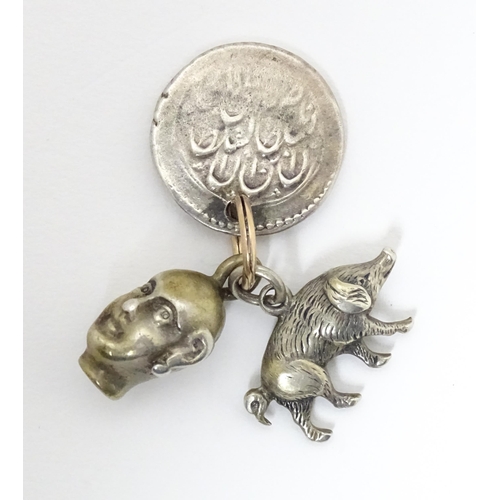 748 - Three assorted charms to include a white metal model of a pig / boar, a buddha head and a coin fob f... 