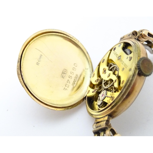 768 - A c.1925 9ct gold cast ladies wristwatch, the dial with engraved decoration, Arabic numerals and sig... 