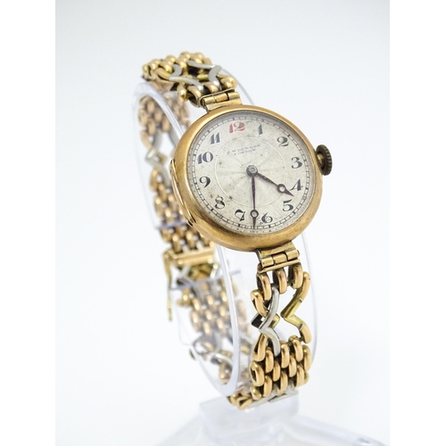 768 - A c.1925 9ct gold cast ladies wristwatch, the dial with engraved decoration, Arabic numerals and sig... 