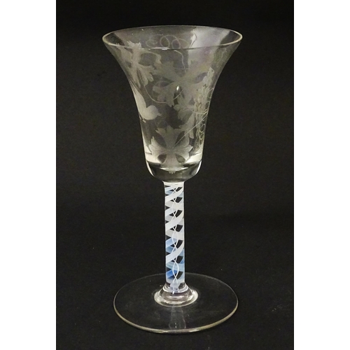 218 - A 19thC pedestal drinking glass with double air twist and etched bird and fruiting vine detail. Appr... 