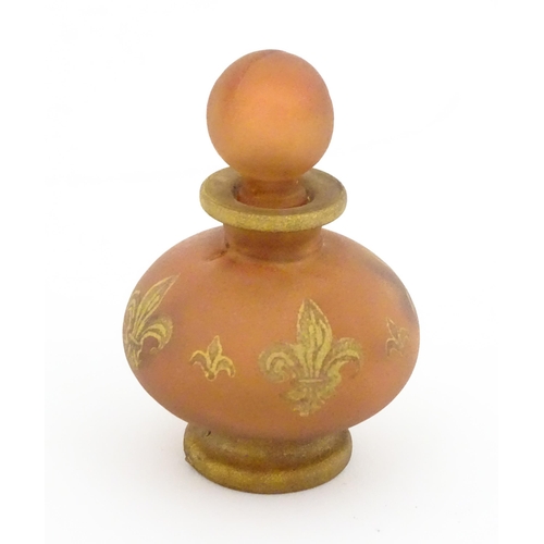 220 - A glass scent / perfume bottle by Jenny Blair with gilt fleur de lys. Approx. 2 3/4