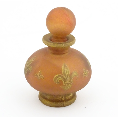 220 - A glass scent / perfume bottle by Jenny Blair with gilt fleur de lys. Approx. 2 3/4