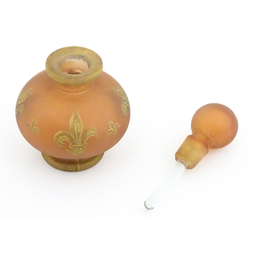 220 - A glass scent / perfume bottle by Jenny Blair with gilt fleur de lys. Approx. 2 3/4