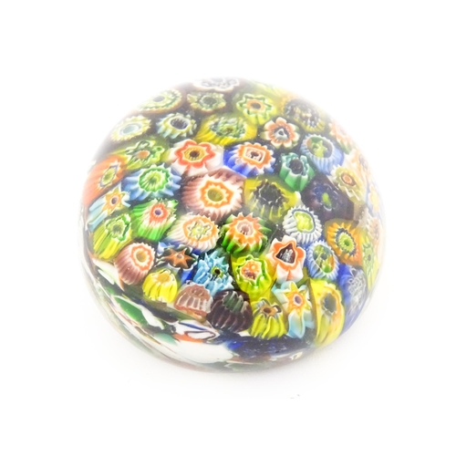 225 - A small glass paperweight with millefiori decoration. Approx. 2 1/2