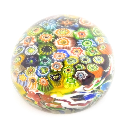 225 - A small glass paperweight with millefiori decoration. Approx. 2 1/2