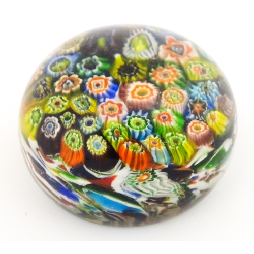 225 - A small glass paperweight with millefiori decoration. Approx. 2 1/2