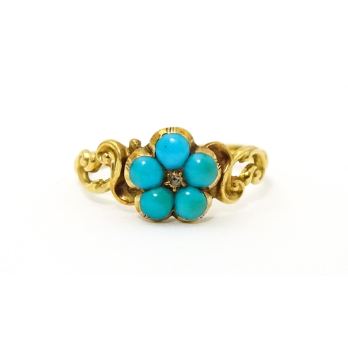 610 - A yellow metal ring set with central diamond bordered by turquoise. Ring size approx K